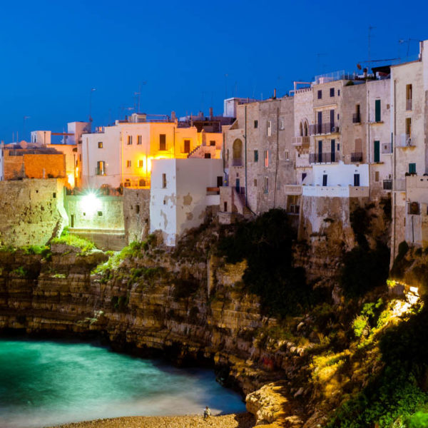 Polignano a Mare at night. Sea and rocks. The old town above the sea